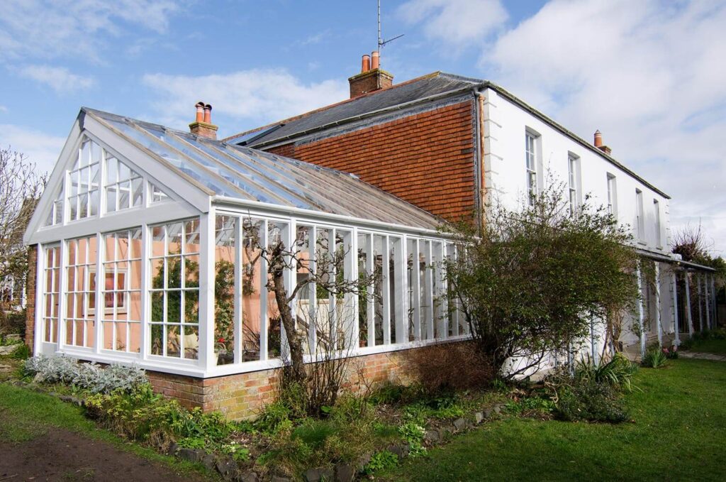 Greenhouse extension to period property made of painted timber and glass. Weymouth, Dorset.